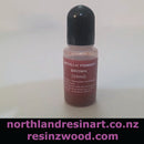 Bottle of metallic pigment with a purple label on a white background, featuring two website URLs at the bottom.