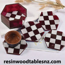 Checkered resin coasters with a small bowl on a white surface, featuring the brand 'resinwoodtablesnz.com'.