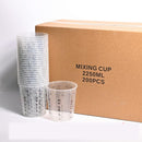 A pack of 200 clear plastic mixing cups with printed measurement markings, shown with a stack of empty cups and one filled cup in front of a brown cardboard box labeled 'MIXING CUP 2250ML 200PCS'.