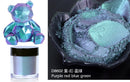 Color sample with a metallic bear figurine and powder, labeled D8602 Purple red blue green.
